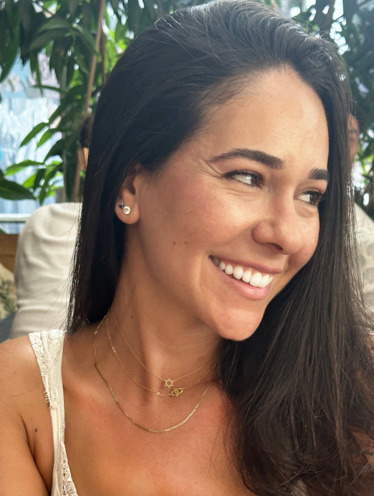 Woman wearing a delicate Mini Hamsa Evil Eye Necklace