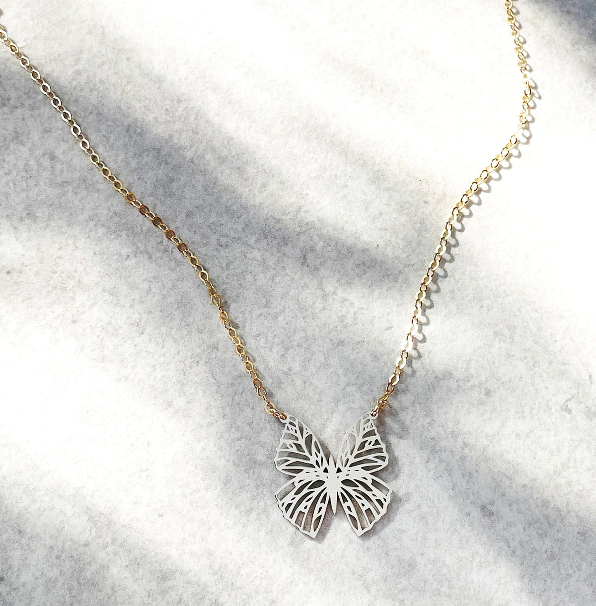Close-up of intricate filigree butterfly pendant necklace